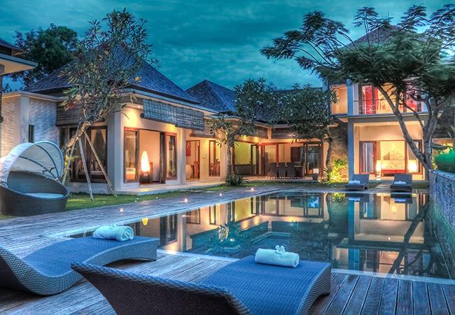 Exterior, garden and pool of a magnificent villa at nightfall 